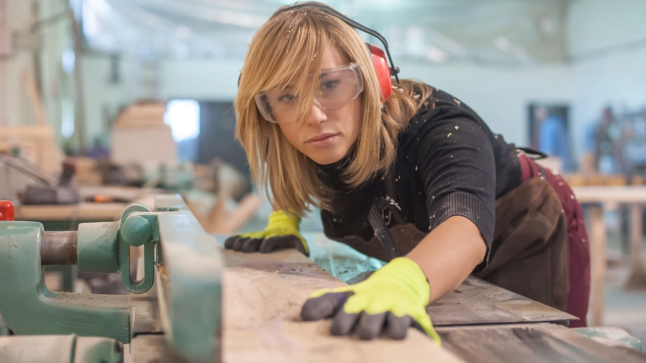 Schreinerin arbeitet an einer Maschine