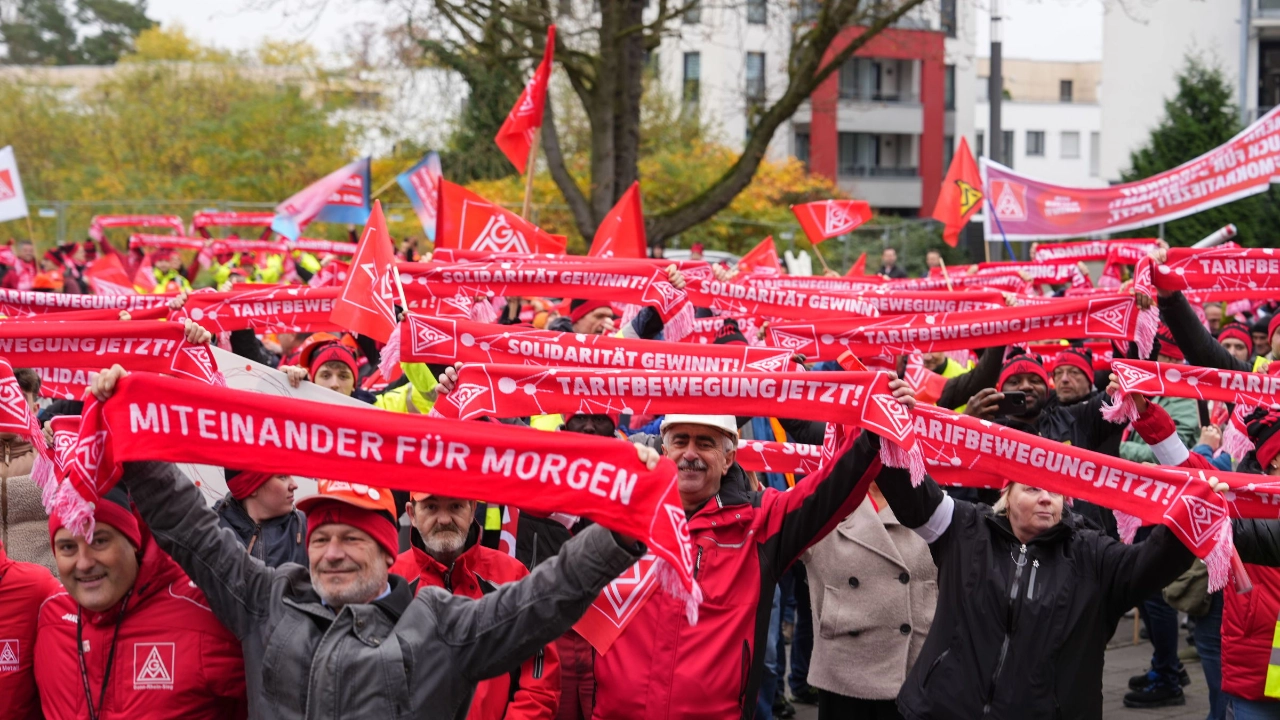 Beschäftigte mit IG Metall-Schals und Fahnen beim Warnstreik in der Metall-Tarifrunde