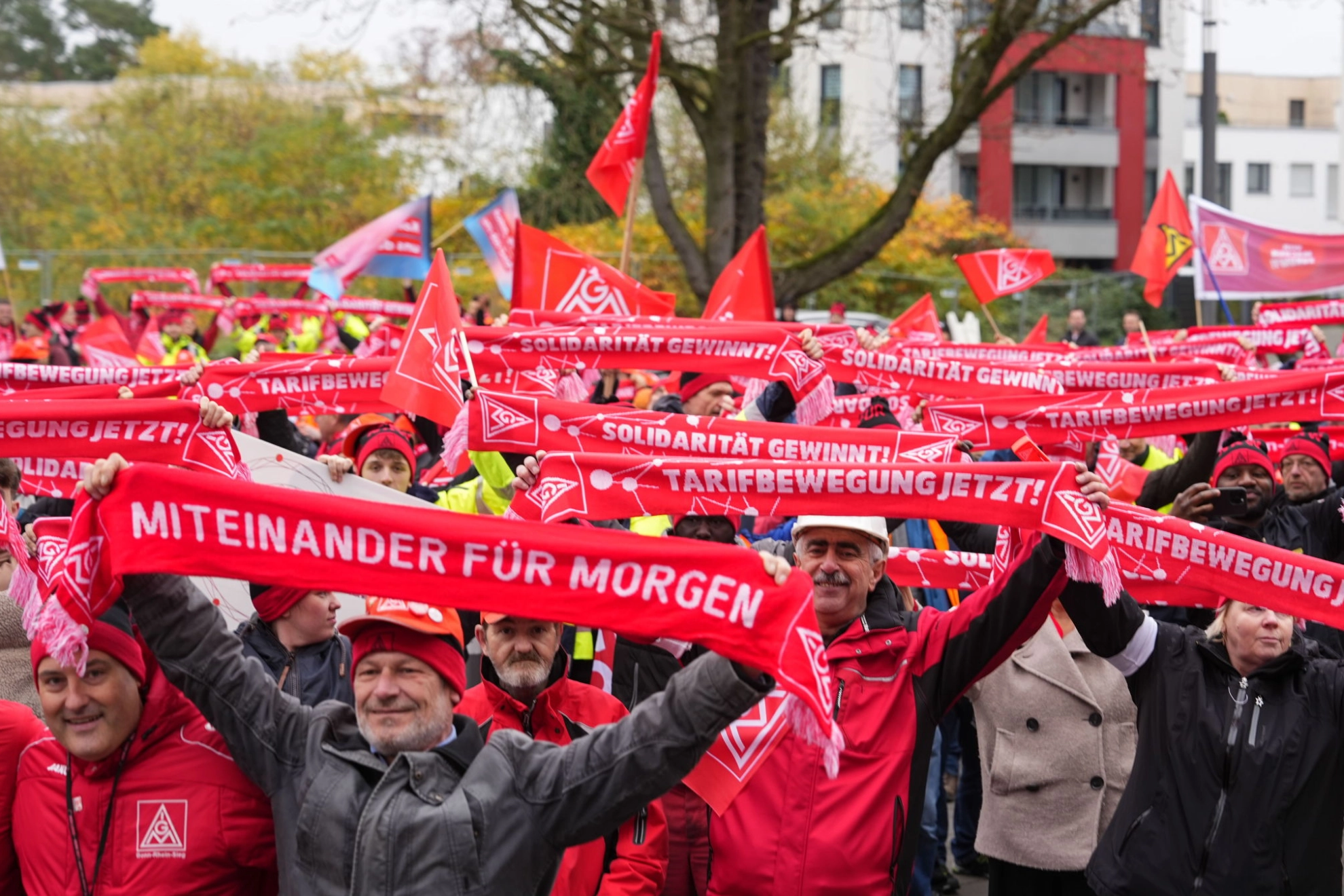 Beschäftigte mit IG Metall-Schals und Fahnen beim Warnstreik in der Metall-Tarifrunde