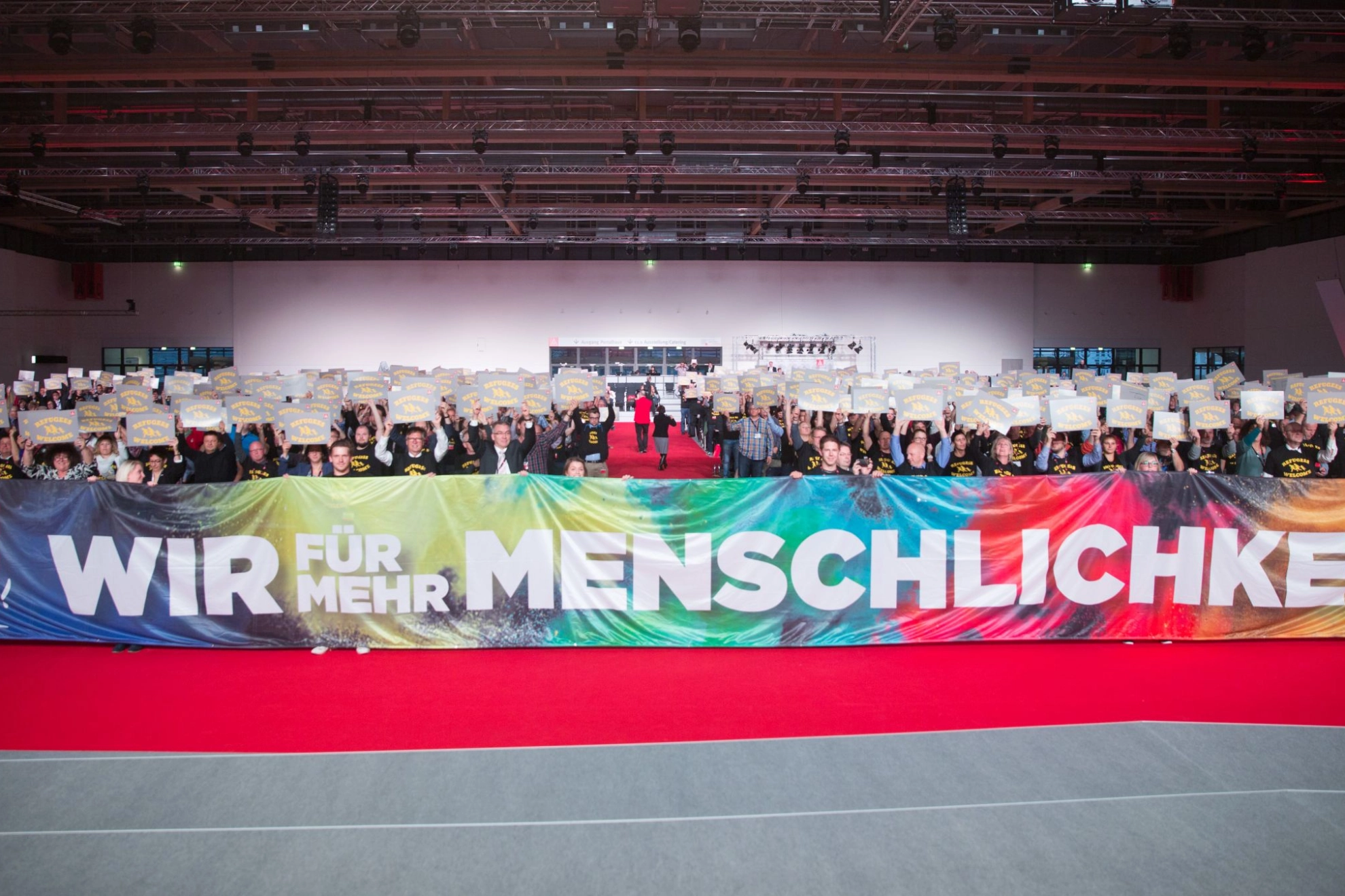 Teilnehmer des Gewerkschaftstags 2015 der IG Metall tragen ein Banner mit der Aufschrift "Wir für mehr Menschlichkeit"