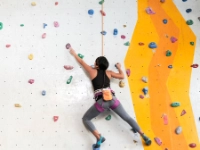 Eine Frau an einer Kletterwand.